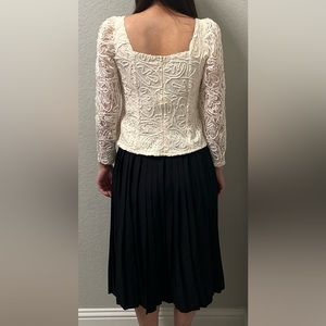 Two piece white long sleeve top with black ruffled skirt